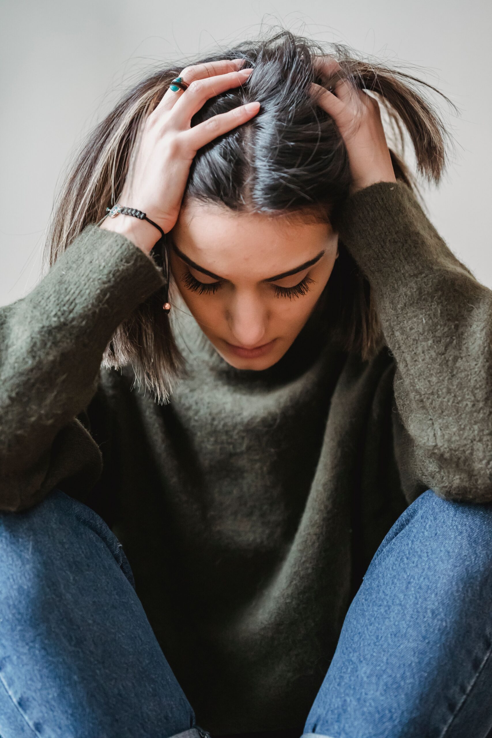 Kobieta załamana psychicznie trzyma się za głowę, trzeba ją skierować na leczenie psychiatryczne w którym pomoże adwokat w Szczecinku